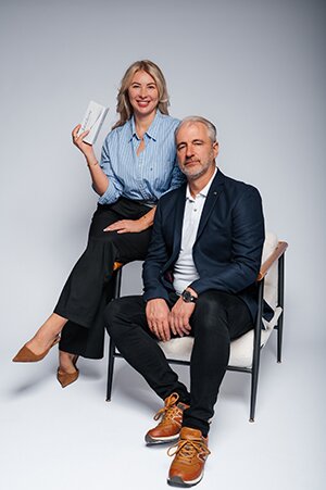 Managing Director Lutz Christian Windisch sitting on a chair with Polina Windisch sitting on the back of the chair